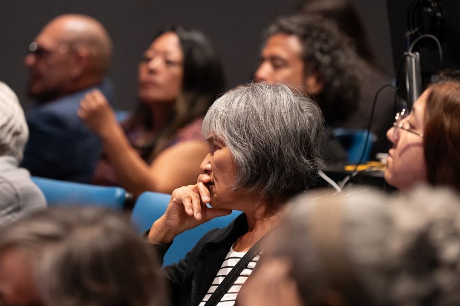 Audience members listening attentively during a screening of the documentary American Exile